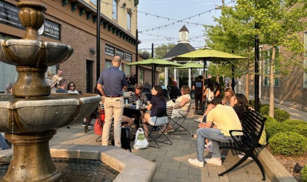 Outdoor dining near fountain with string lights and umbrellas