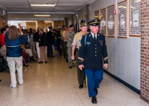 Military personnel walking in school hallway event.