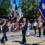 Veterans marching with flags in a parade.