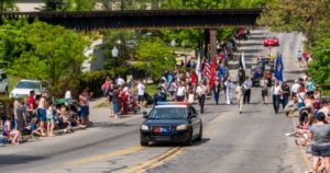 Town parade with spectators and marching band.