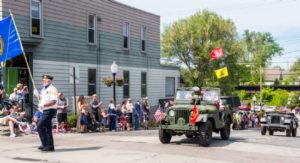 Parade with military vehicles and spectators.