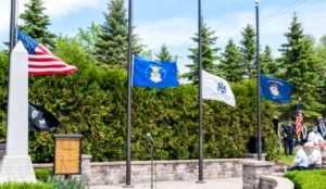 American flag and military flags at outdoor memorial site.