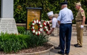 Veterans laying wreath at memorial dedication ceremony.