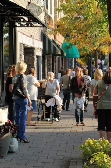 People strolling on sunny downtown sidewalk.