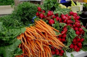 Fresh carrots and radishes at a farmers market.