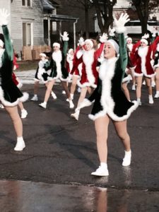 Parade dancers in festive elf costumes celebrating.