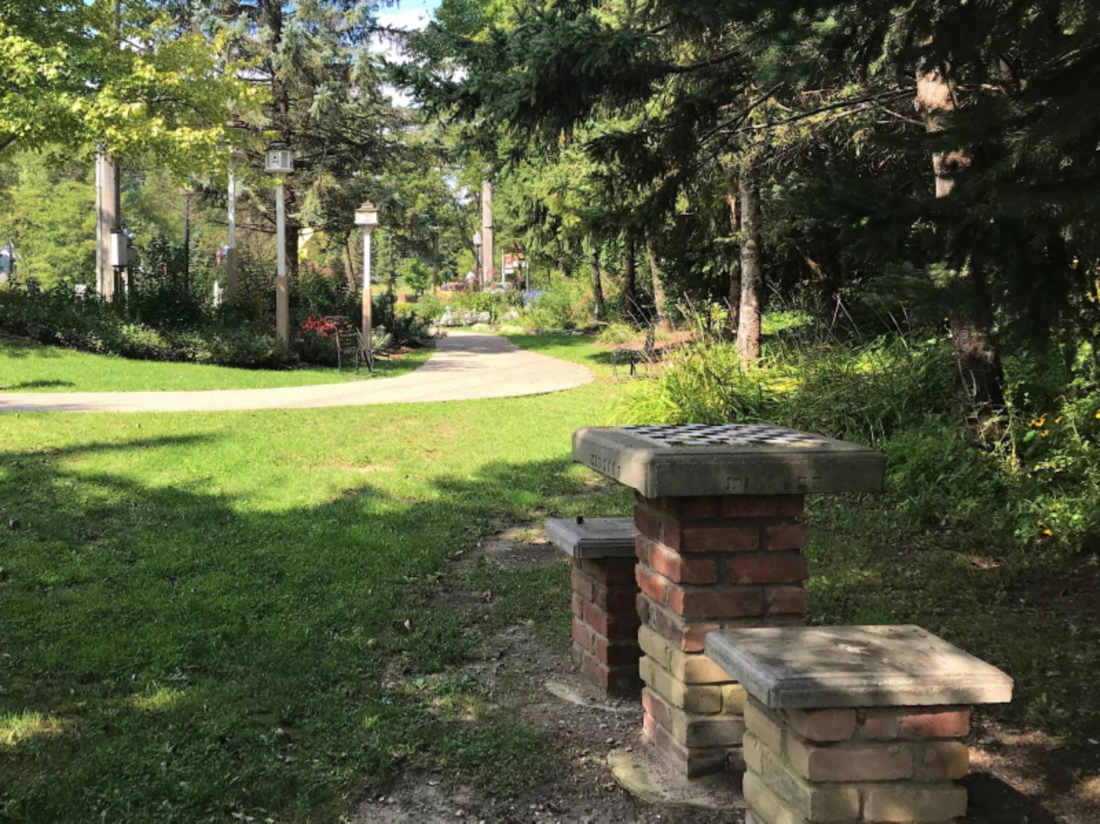 Brick barbecue pits beside a tranquil park pathway