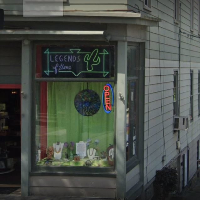 Storefront with "Legends of Time" neon sign and open indicator.